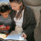 Older woman reading to young child