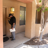 Constable knocking on front door of a home.