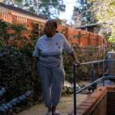 Woman standing outside her home.