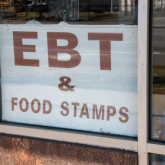 EBT and food stamps sign in store window.