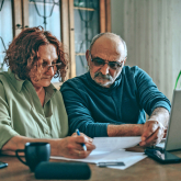 Older adult couple paying bills.