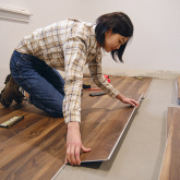 Asian woman installing click flooring