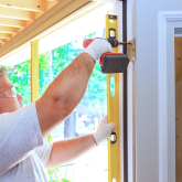 Man installing new exterior door on a home.
