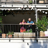 Two people on an apartment balcony.