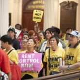 Tenant advocates at the MA State House with signs supporting rent control.