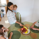 Mother and three kids at kitchen table.