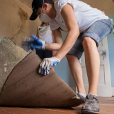 Person pulling up flooring.