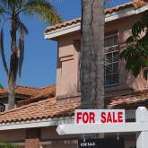 Home with a for sale sign in front. 