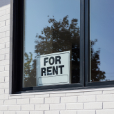 For rent sign in an apartment window.