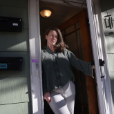 Woman standing in doorway of a home.