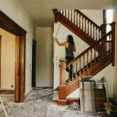 Woman on a staircase remodeling an old home.
