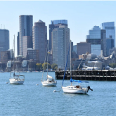 Boats in Boston harbor with buildings in the background.