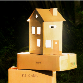 House made of cardboard sitting atop moving boxes.