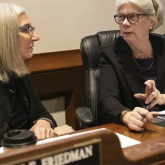 Senator Cindy Friedman and Representative Alice Peisch sit at a desk talking.