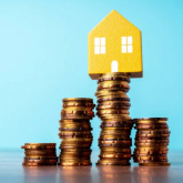 Illustration of a house on top of stacks of coins.