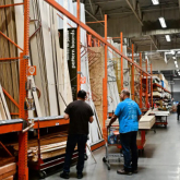 People in the lumber section of a home improvement store.