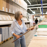 Woman browsing flooring at a home improvement store.