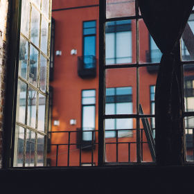 View of a brick multifamily building through a window.