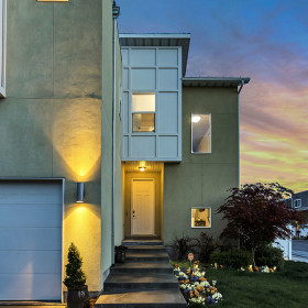 Front door of a house lit up at dusk.