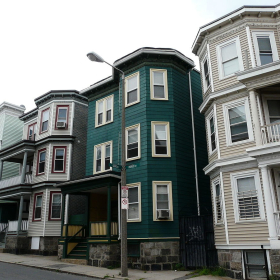View of triple-decker apartments on a street in Boston.