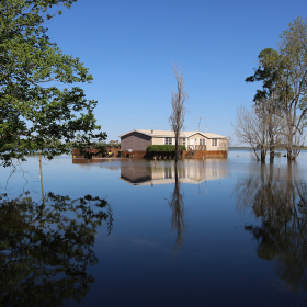 A small house surrounded by floodwater.