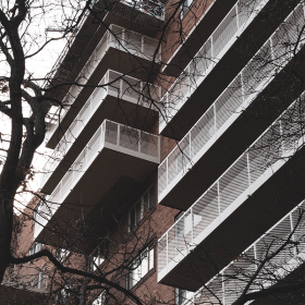 Large brick apartment building with rows of balconies.