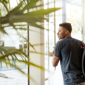 Student with a backpack walking through a door