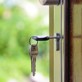 Key in open door of home.