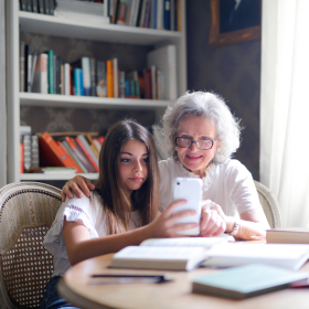 Older adult woman with granddaughter and cell phone