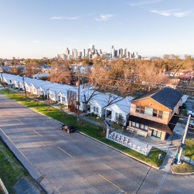 Aerial view of row houses with city skyline behind them