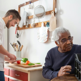 Caregiver cooks food for Black older adult resident