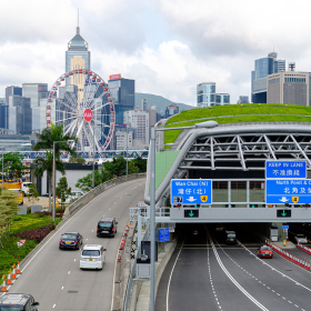 Highway and tunnel against Hong Kong skyline.