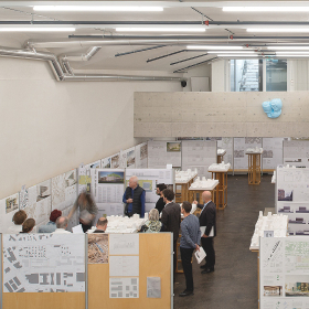 Group reviewing competition proposals in a modern space.