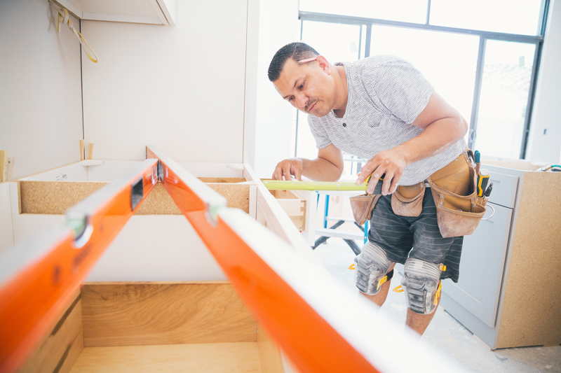Contractor measuring kitchen counters for a remodeling project