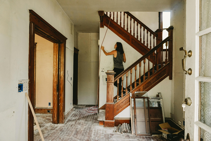 Woman on a staircase remodeling an old home.