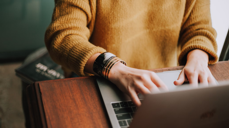 Woman typing on a laptop. 