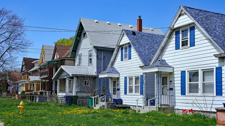 Row of small wooden houses with front yards.