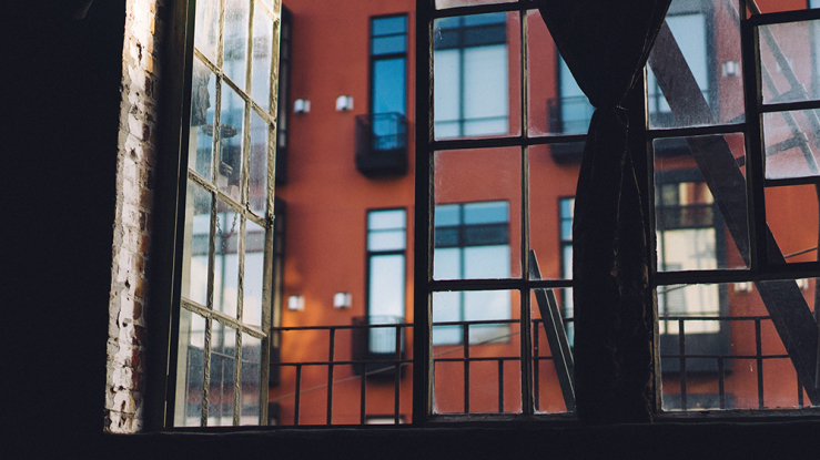 View of a brick multifamily building through a window.