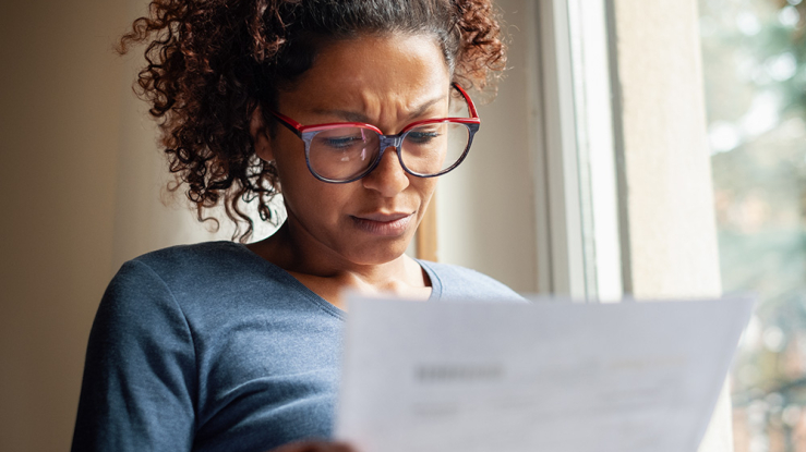 Worried woman considers bill.