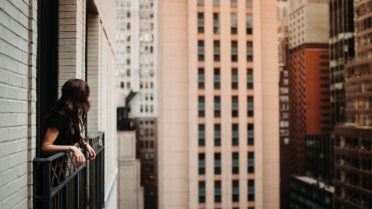 Woman on balcony in New York City.