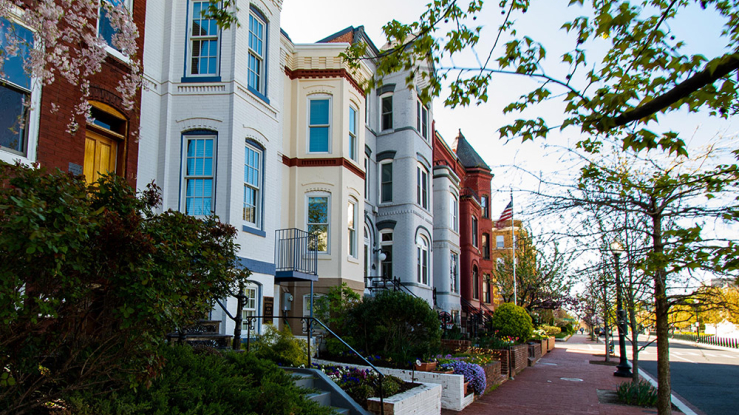 View of brick townhouses on a residential street.