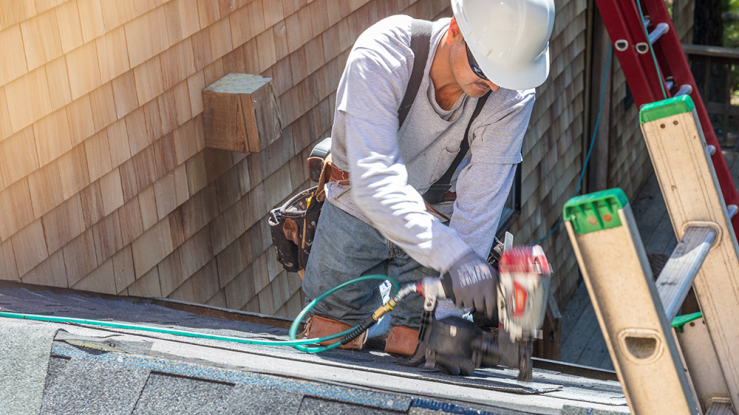 Roofer working on partially finished roof.