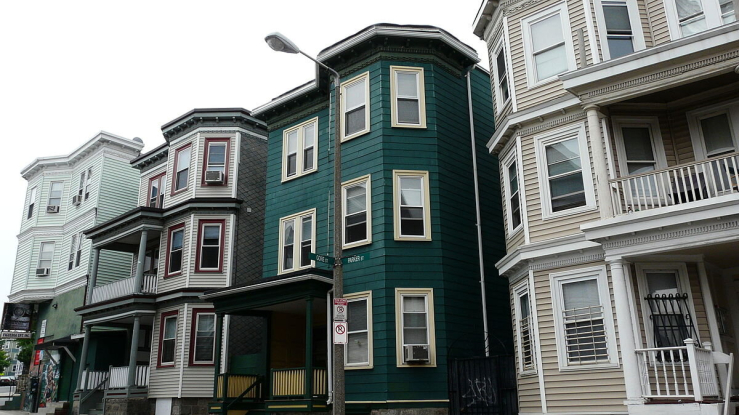 View of triple-decker apartments on a street in Boston.