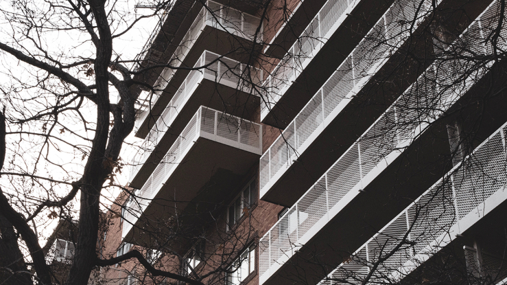 Large brick apartment building with rows of balconies.