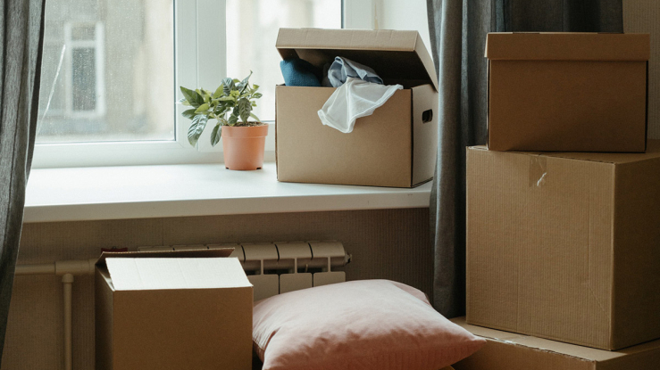 Moving boxes stacked by apartment window.