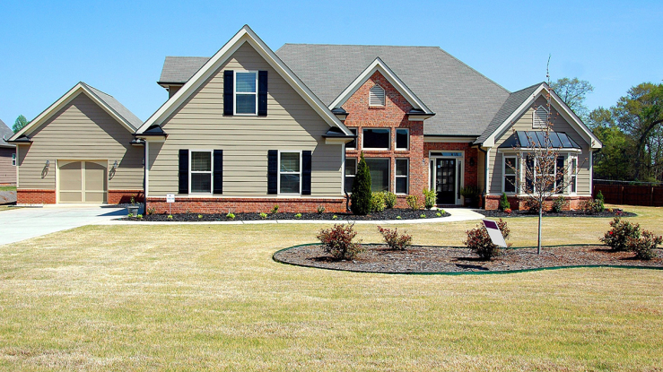 Large home with for-sale sign.