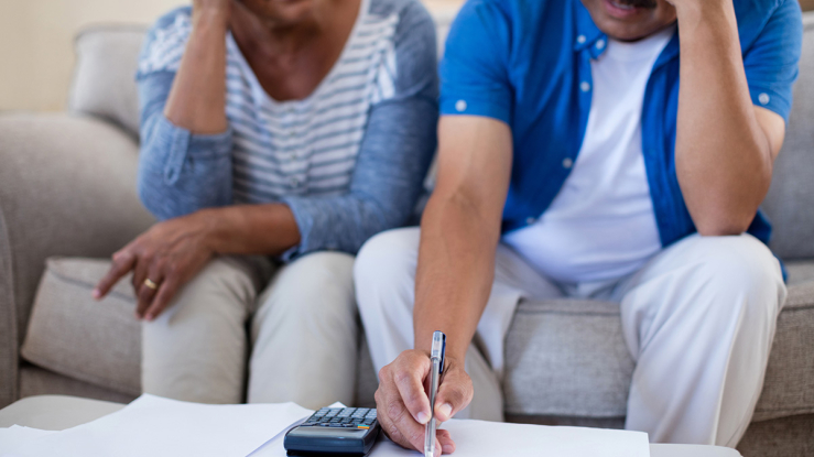 Older couple paying bills looking worried.