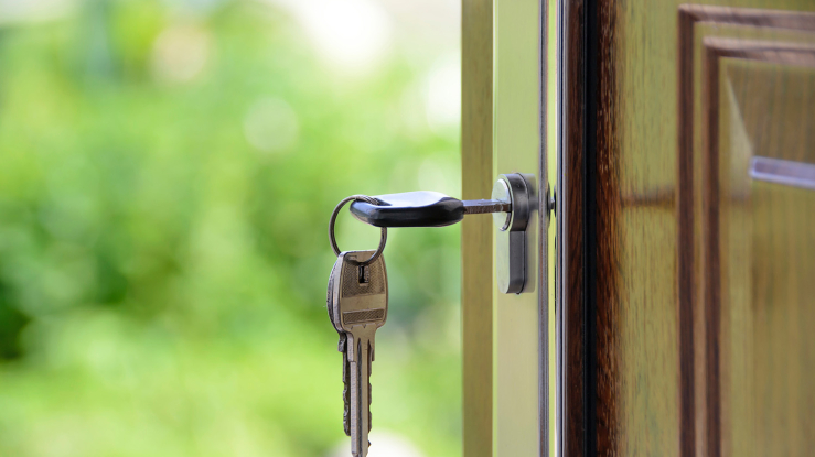 Key in open door of home.