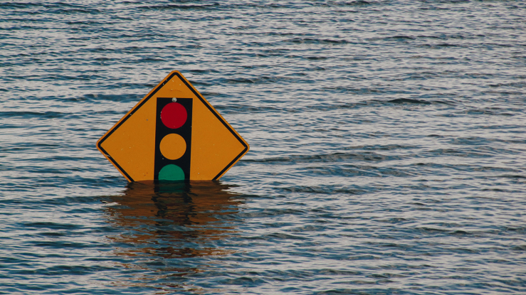 Street sign submerged in flood water.