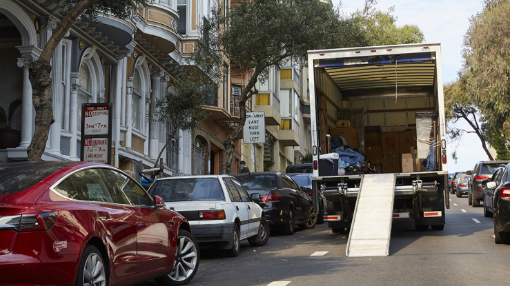 Moving truck parked on steep residential street.